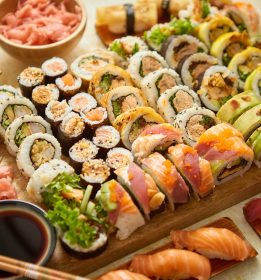 Above view of various sushi and rolls placed on wooden board. Japanese food fest. Top view, flat lay.